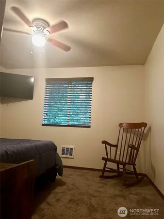 a bedroom with a bed chair and a window