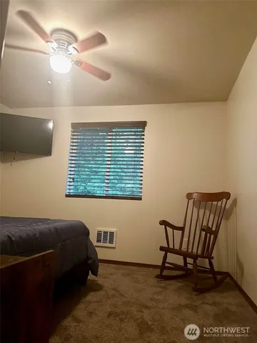 a bedroom with a bed chair and a window