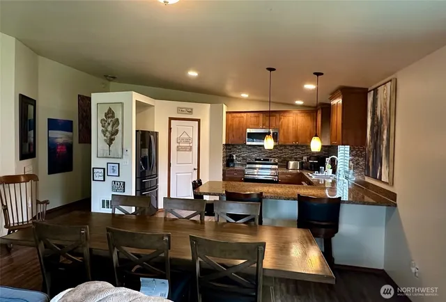 a kitchen with stainless steel appliances kitchen island granite countertop a refrigerator and microwave