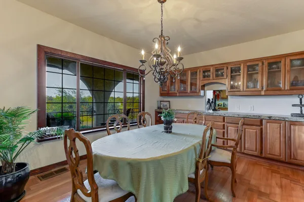 a dining room with furniture a chandelier and wooden floor