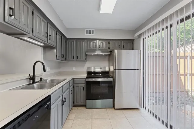 a kitchen with stainless steel appliances granite countertop a refrigerator sink and stove