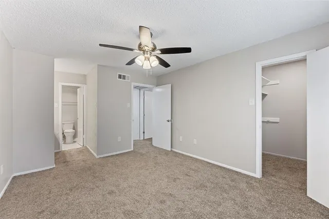 a view of an empty room and a ceiling fan