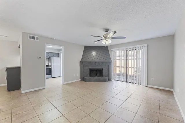 a view of an empty room with a fireplace and a window