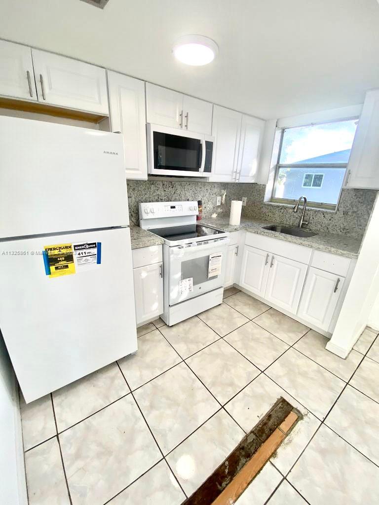 a kitchen with stainless steel appliances a refrigerator sink and microwave