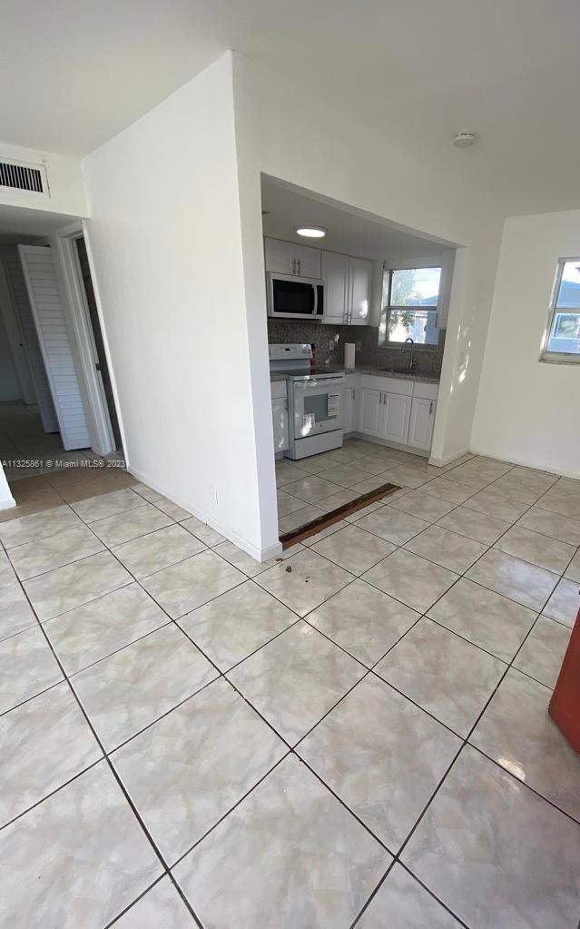 850 Southwest 74th Terrace, Unit 2 Pompano Beach, FL 33068 - Photo 2 of 11 a view of an empty room and kitchen view