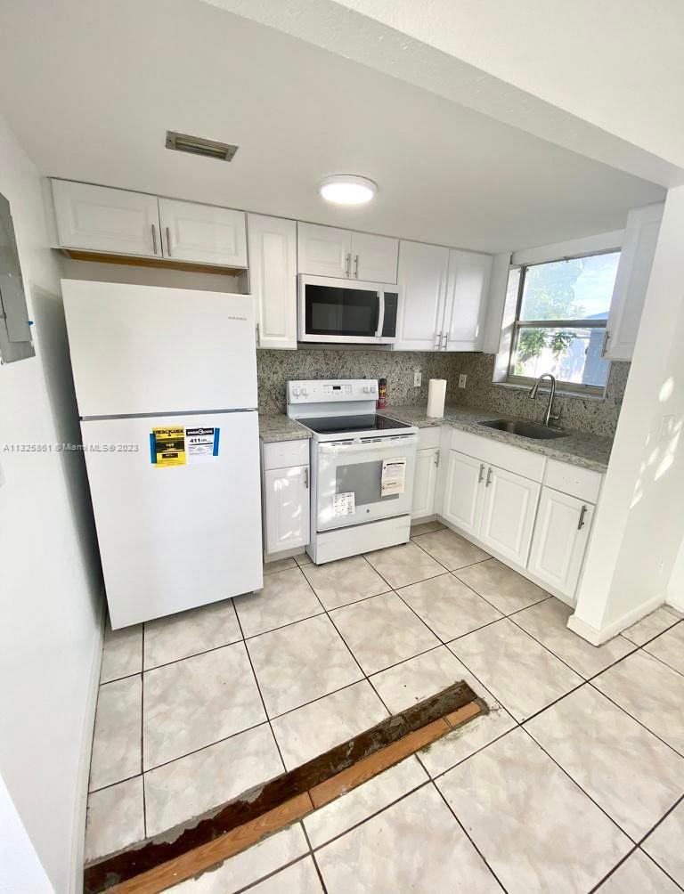 850 Southwest 74th Terrace, Unit 2 Pompano Beach, FL 33068 - Photo 3 of 11 a kitchen with stainless steel appliances a refrigerator sink and microwave