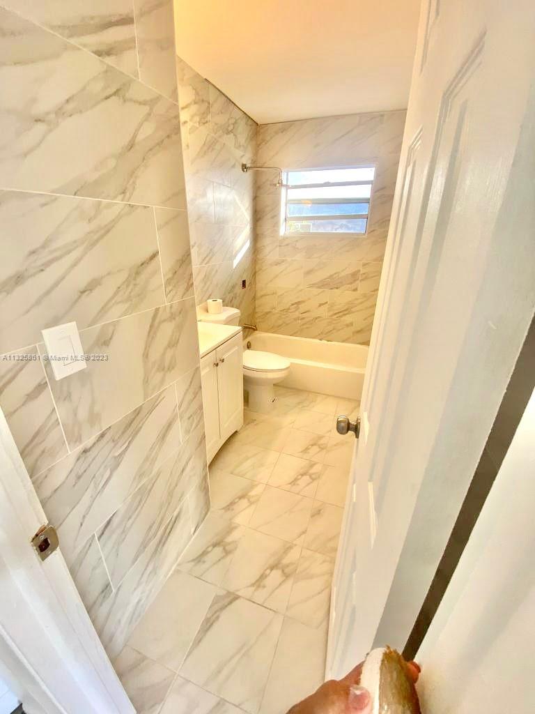850 Southwest 74th Terrace, Unit 2 Pompano Beach, FL 33068 - Photo 4 of 11 a bathroom with a granite countertop window and a sink