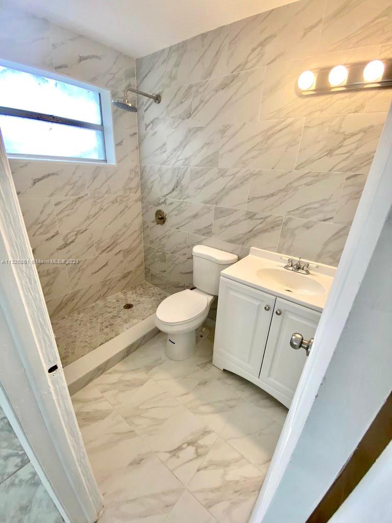 850 Southwest 74th Terrace, Unit 2 Pompano Beach, FL 33068 - Photo 7 of 11 a bathroom with a toilet sink and shower