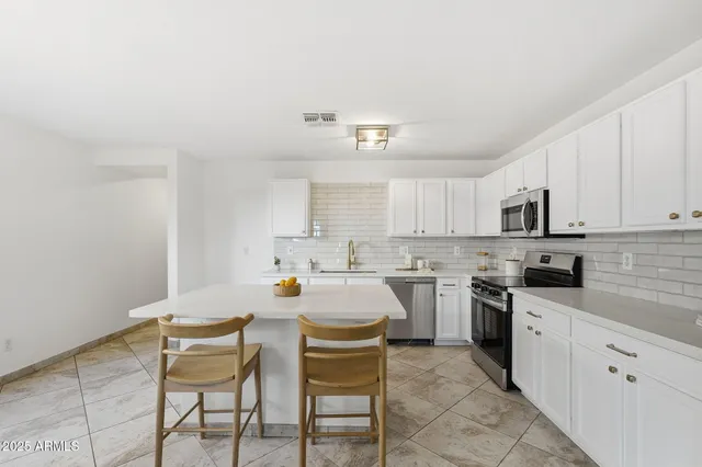 a kitchen with a cabinets and chairs