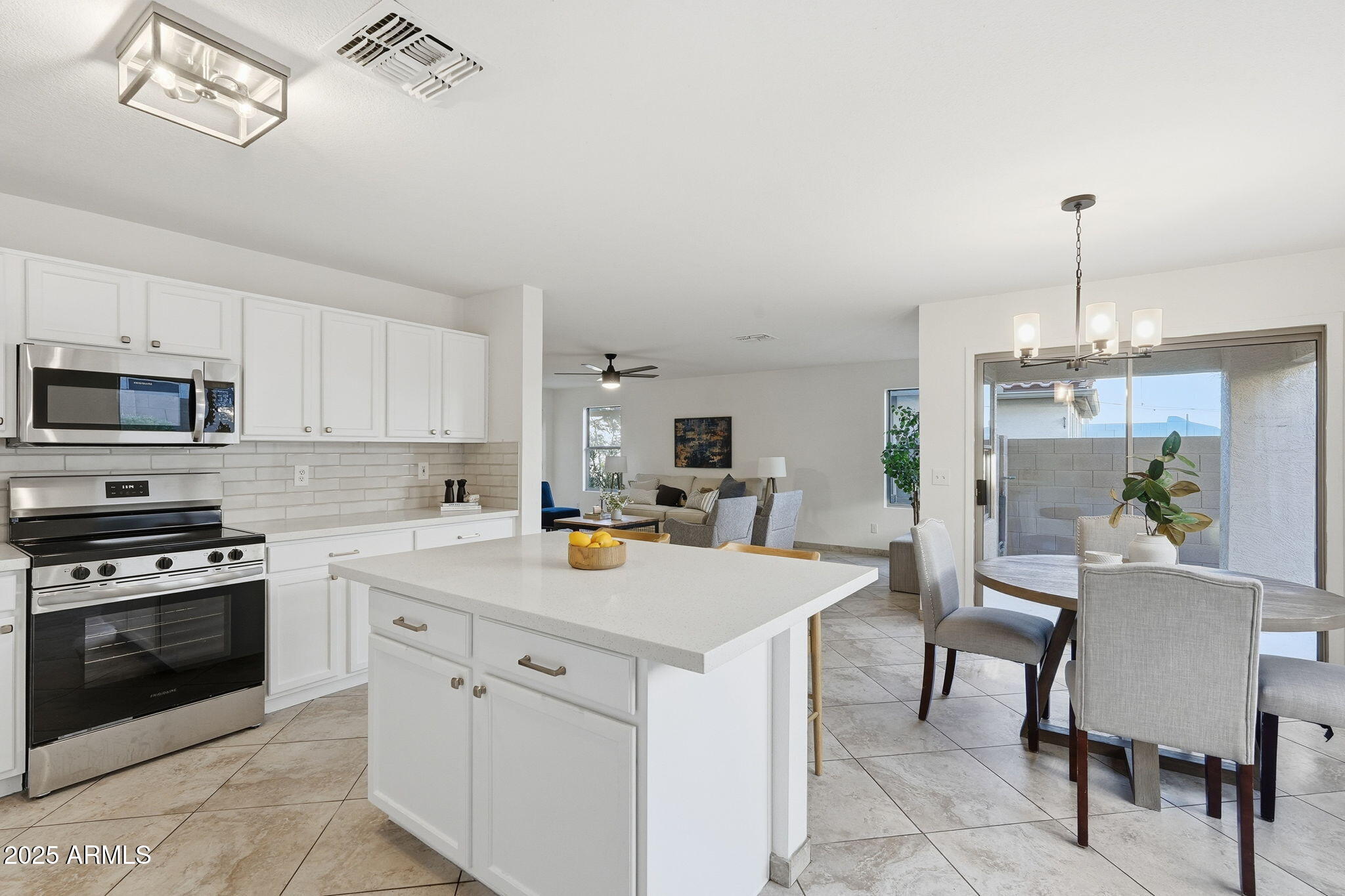 3287 South Bowman Road Apache Junction, AZ 85119 - Photo 9 of 38 a kitchen with a stove a sink dishwasher a dining table and chairs with wooden floor