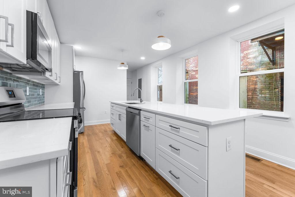 51 South Fulton Avenue Baltimore, MD 21223 - Photo 11 of 44 a kitchen with granite countertop a sink stainless steel appliances and cabinets
