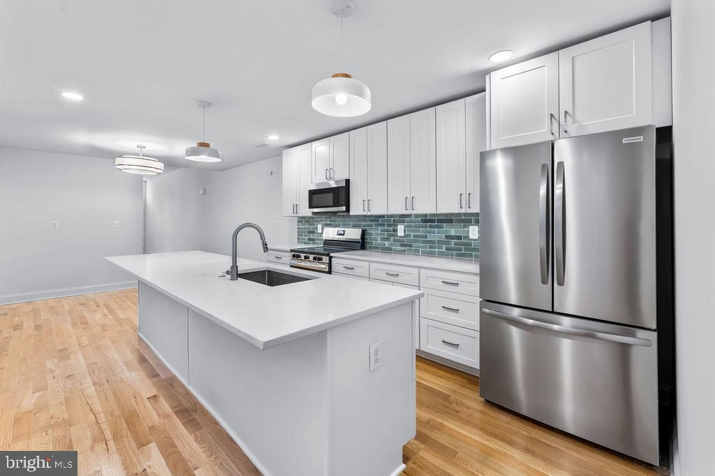 51 South Fulton Avenue Baltimore, MD 21223 - Photo 12 of 44 a kitchen with appliances a sink and a refrigerator