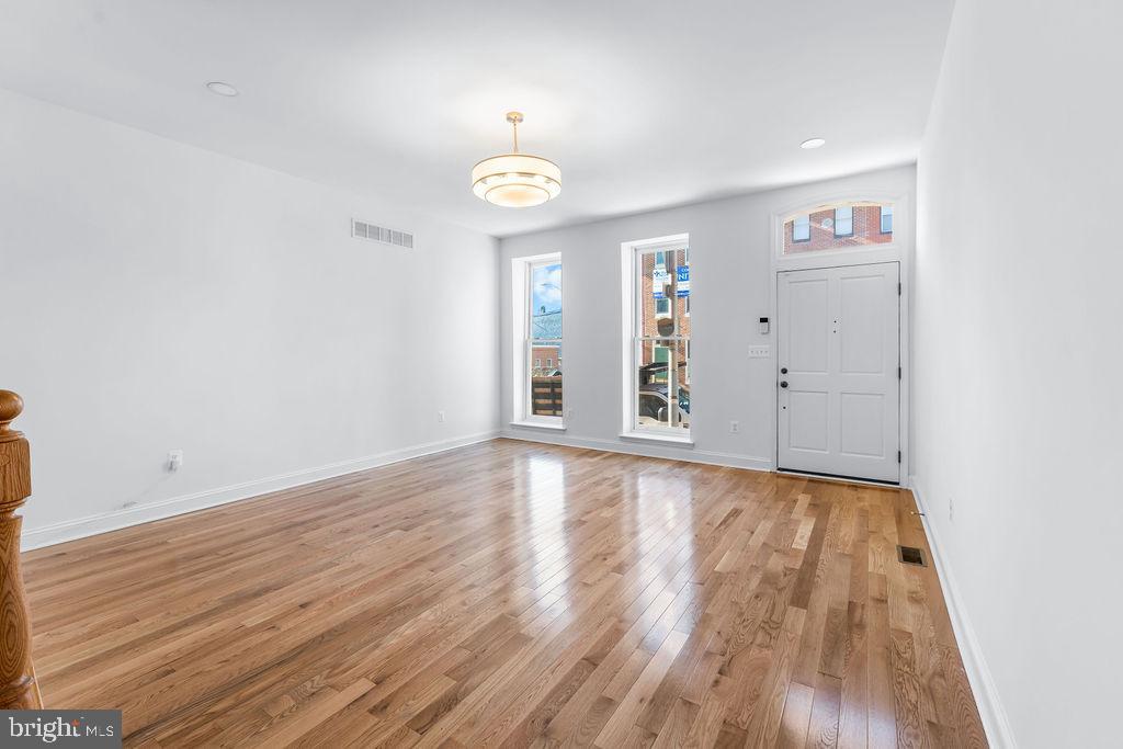 51 South Fulton Avenue Baltimore, MD 21223 - Photo 5 of 44 an empty room with wooden floor and windows