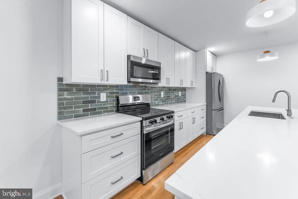 51 South Fulton Avenue Baltimore, MD 21223 - Photo 9 of 44 a kitchen with stainless steel appliances white cabinets and a sink