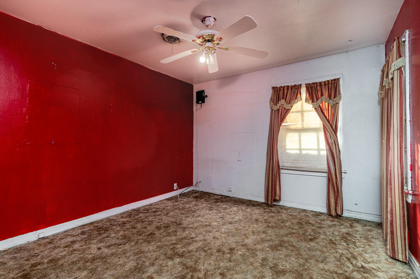 210 North Floyd Avenue Tulia, TX 79088 - Photo 12 of 35 an empty room with a window and a chandelier fan