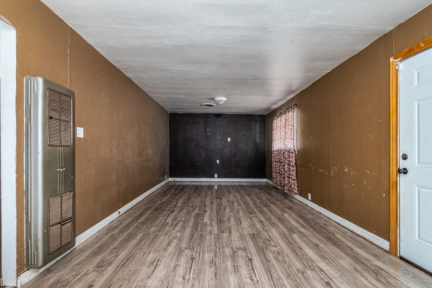 210 North Floyd Avenue Tulia, TX 79088 - Photo 6 of 35 a view of an empty room with wooden floor and a window