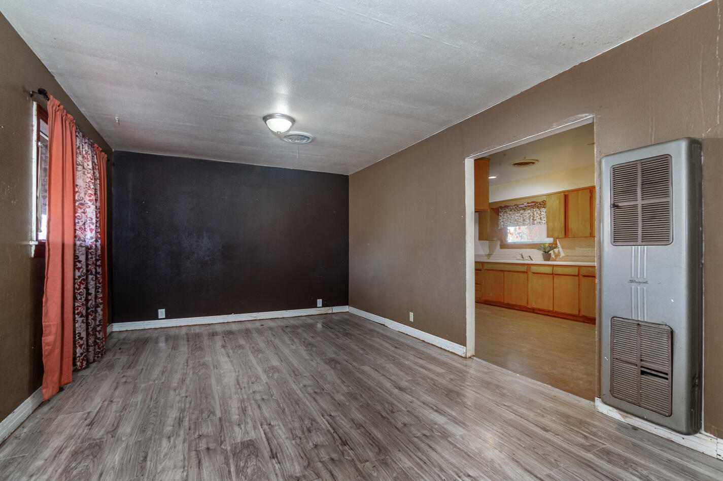 210 North Floyd Avenue Tulia, TX 79088 - Photo 7 of 35 a view of a hallway with wooden floor and a kitchen