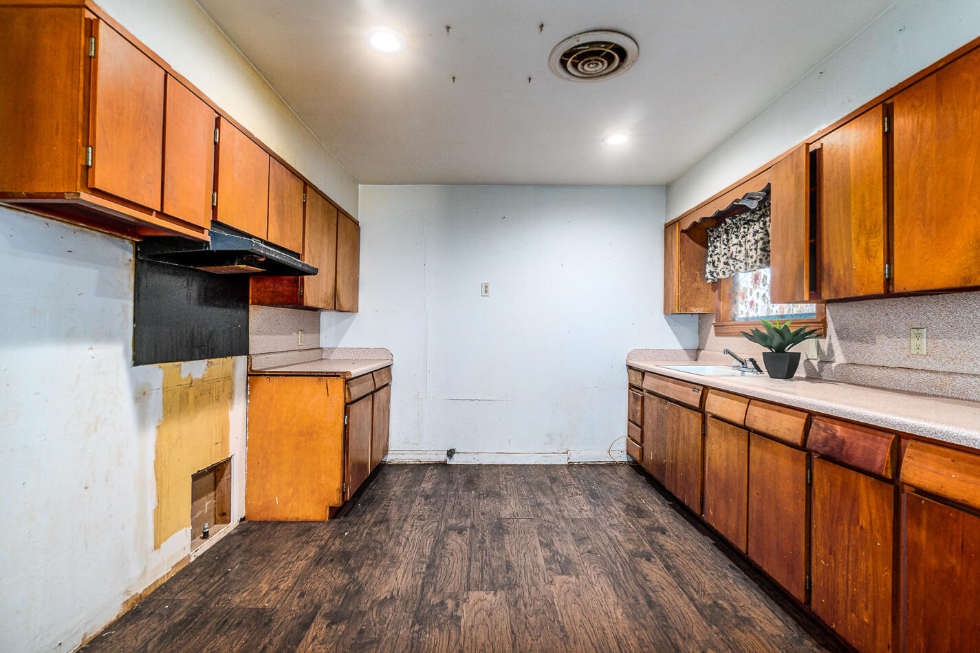 210 North Floyd Avenue Tulia, TX 79088 - Photo 8 of 35 a view of a kitchen with wooden floor and a sink