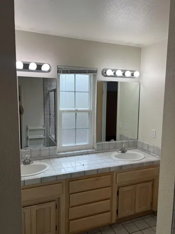a bathroom with a double vanity sink and a mirror