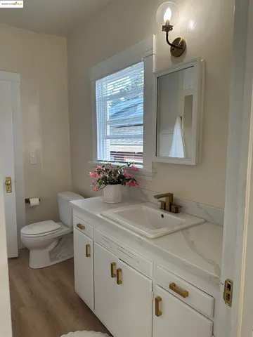 an empty room with wooden floor mirror and windows