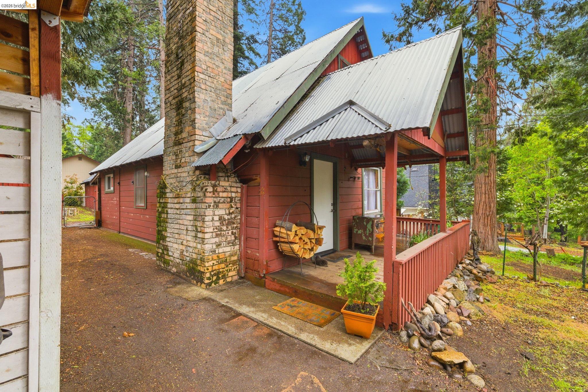 24249 Sugarpine Road Mi Wuk Village, CA 95383 - Photo 1 of 18 a view of a house with wooden fence