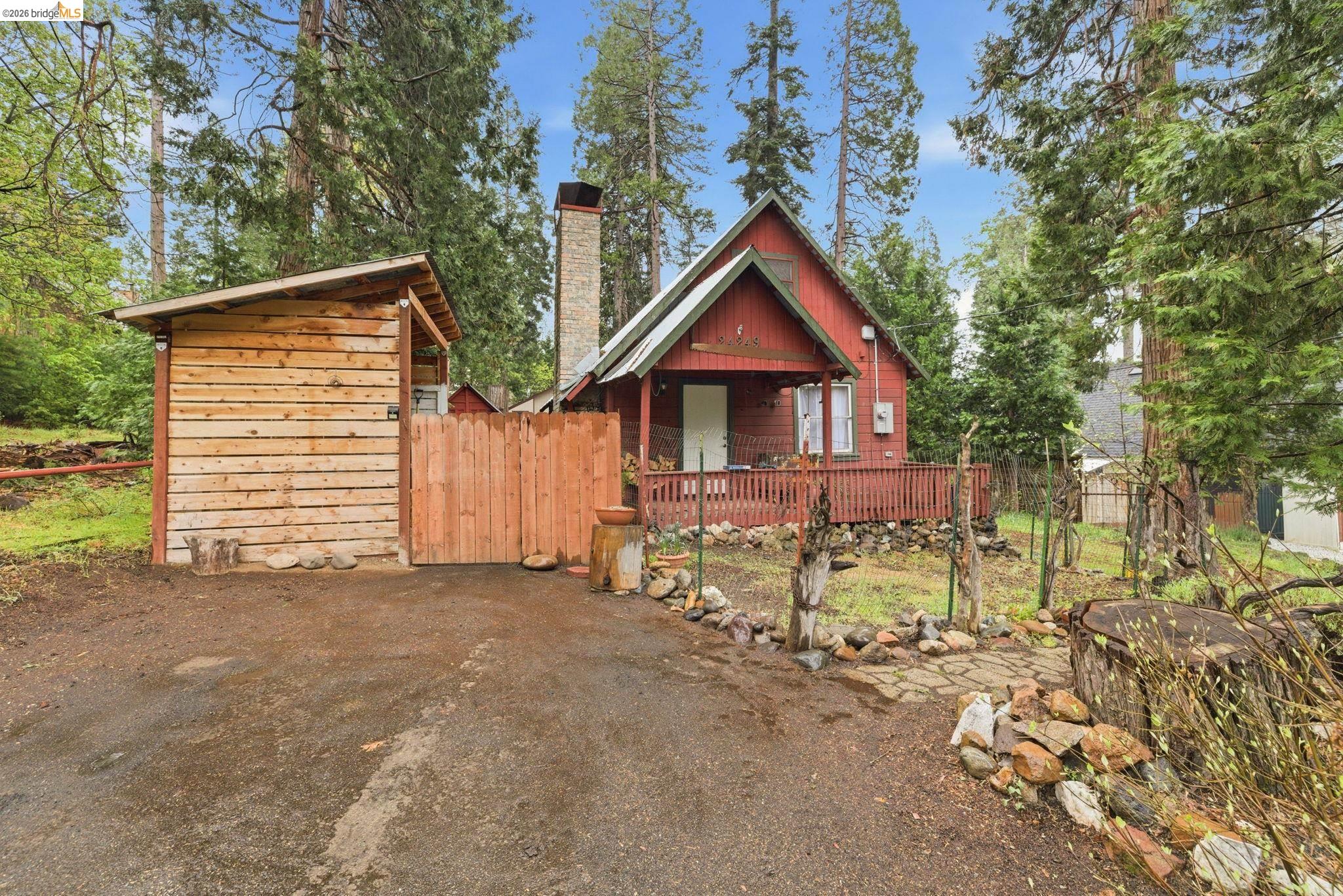 24249 Sugarpine Road Mi Wuk Village, CA 95383 - Photo 2 of 18 a view of a house with a yard and lawn chairs
