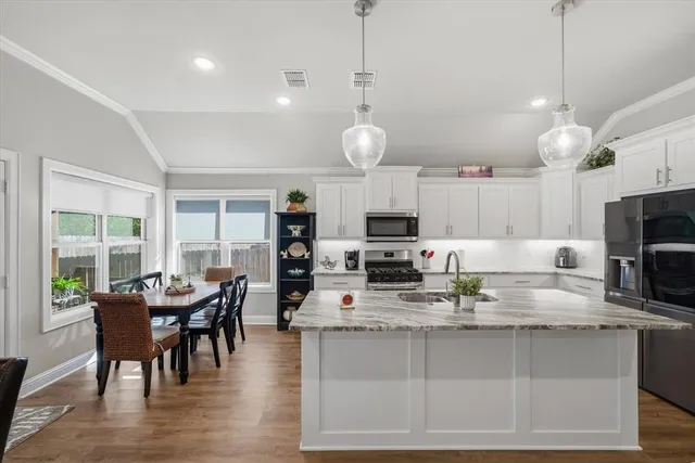 a kitchen with microwave a stove and chairs