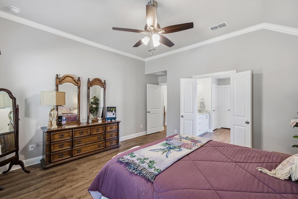 10059 Dayspring Drive Flint, TX 75762 - Photo 22 of 37 a bedroom with a large bed and a chandelier