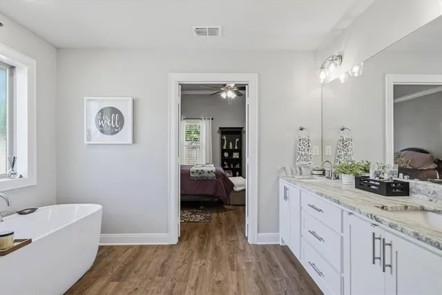 a spacious bathroom with a double vanity sink a mirror and a shower