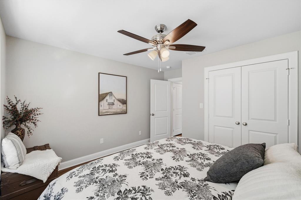 10059 Dayspring Drive Flint, TX 75762 - Photo 31 of 37 a bedroom with a large bed and a chandelier