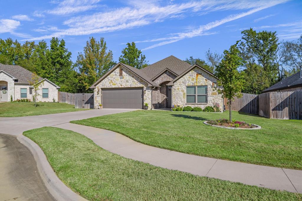 10059 Dayspring Drive Flint, TX 75762 - Photo 5 of 37 a front view of a house with a garden and trees
