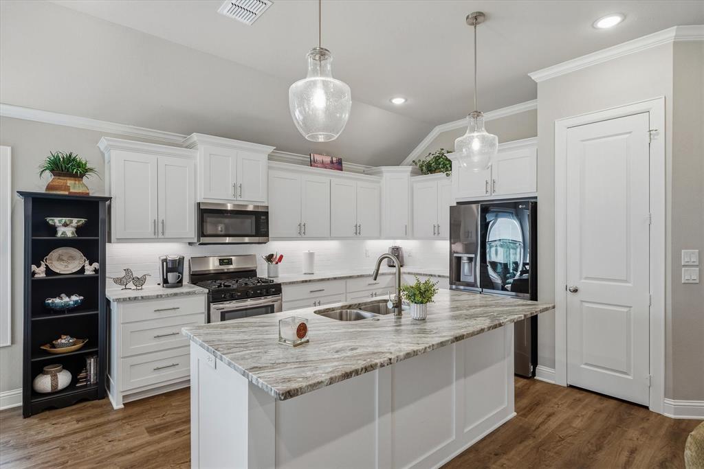 10059 Dayspring Drive Flint, TX 75762 - Photo 8 of 37 a kitchen with stainless steel appliances kitchen island granite countertop a sink dishwasher a refrigerator and a stove with wooden floor