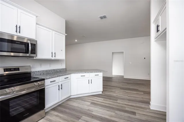 a kitchen with a sink stove top oven and cabinets