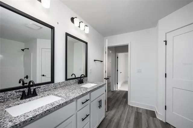 a bathroom with a granite countertop sink and a mirror