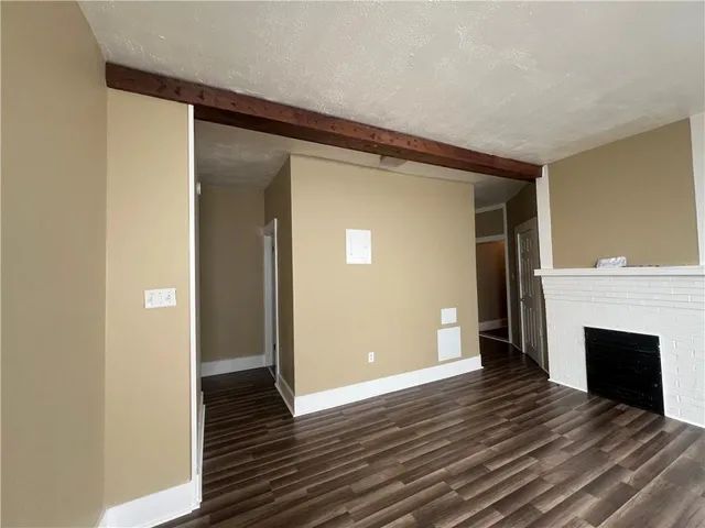 a view of a livingroom with wooden floor and a fireplace