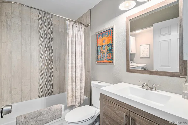 a bathroom with a granite countertop sink toilet mirror vanity and shower