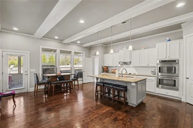 a kitchen with kitchen island a dining table chairs and wooden floor