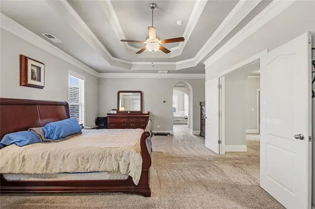 a spacious bedroom with a bed and a chandelier