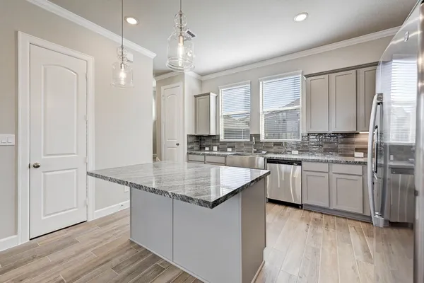 a kitchen with stainless steel appliances granite countertop a sink stove and refrigerator