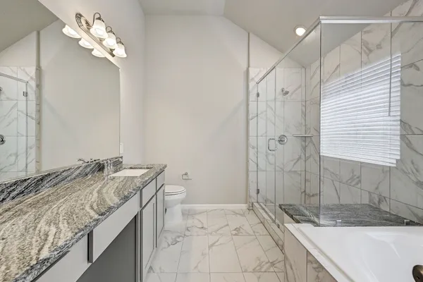 a bathroom with a granite countertop sink a mirror and shower