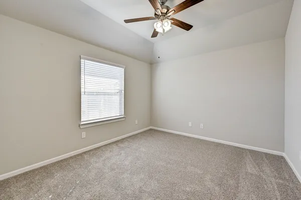 an empty room with a window and a fan