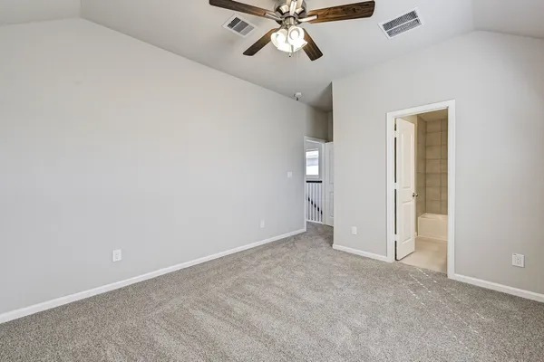 a view of a room with a ceiling fan and carpet
