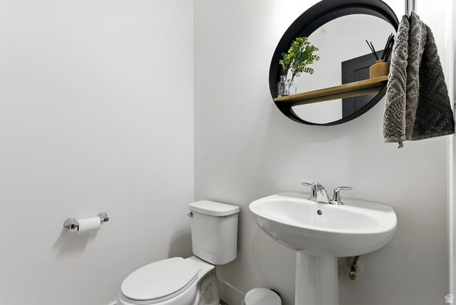 6039 North Westridge Road Heber City, UT 84032 - Photo 7 of 22 Pedestal sink with chrome fixtures and an oval black-framed mirror featuring a wood shelf
