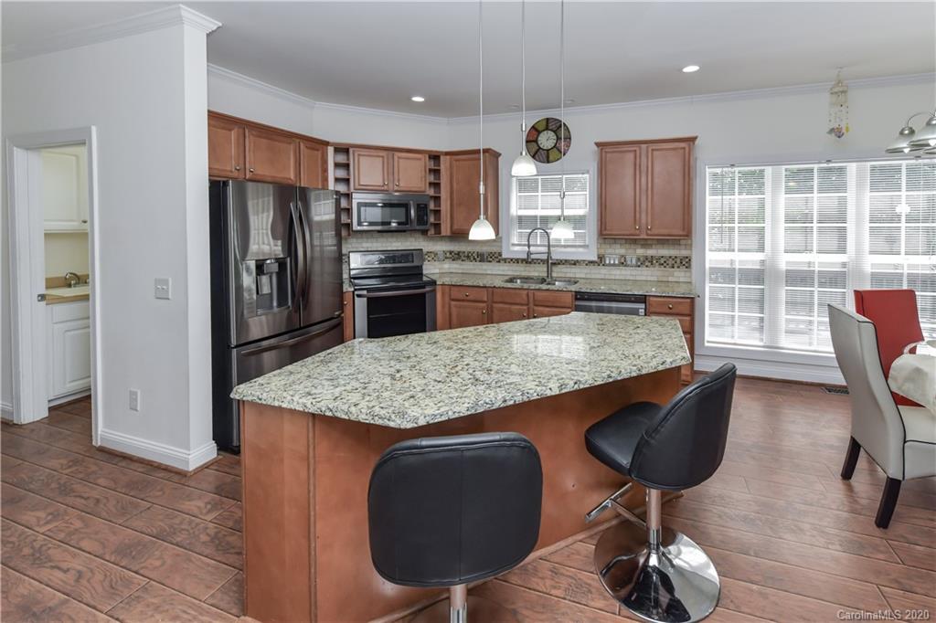 2425 Lakeview Circle Matthews, NC 28105 - Photo 13 of 33 a kitchen with stainless steel appliances granite countertop a kitchen island a stove a sink a refrigerator and chairs