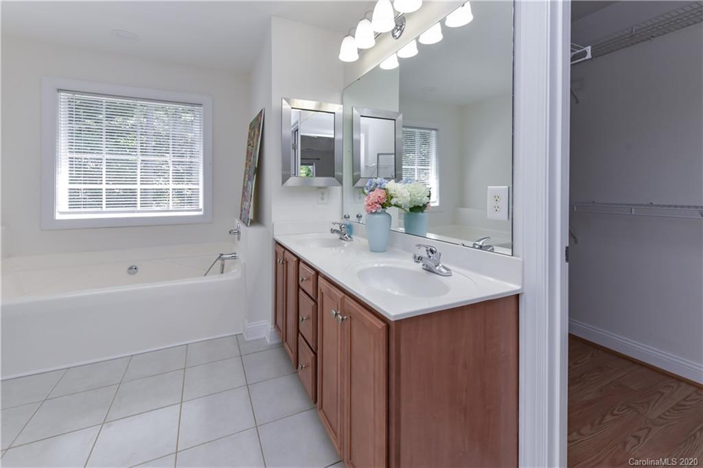 2425 Lakeview Circle Matthews, NC 28105 - Photo 25 of 33 a bathroom with a sink a large mirror and a bathtub
