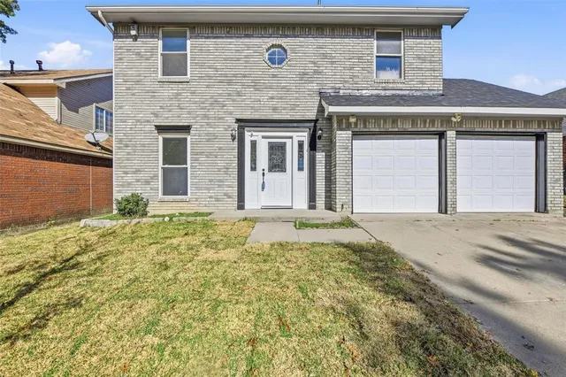 front view of a brick house with a yard