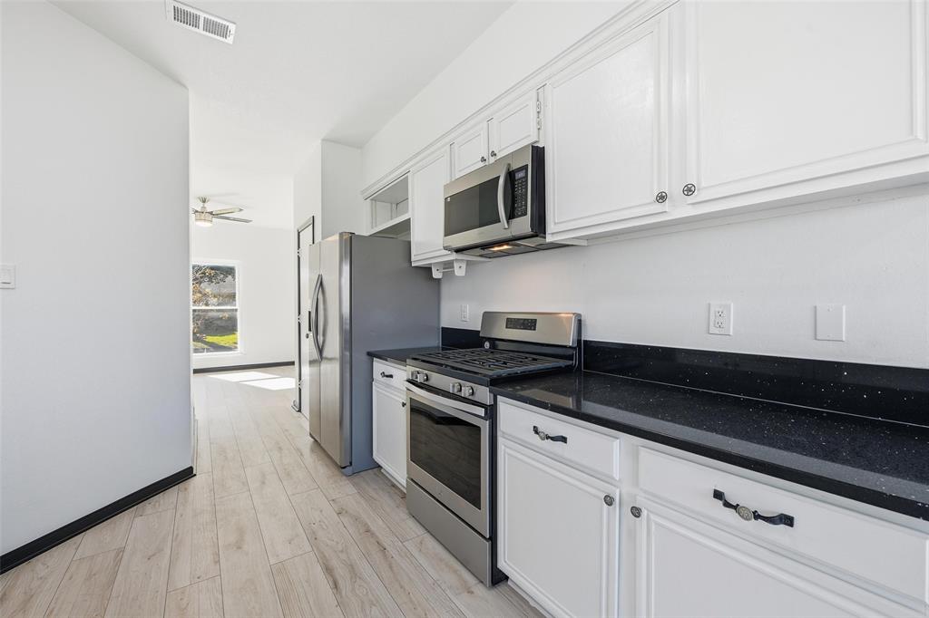 10120 Long Rifle Drive Fort Worth, TX 76108 - Photo 10 of 28 a kitchen with stainless steel appliances granite countertop a stove a microwave and a refrigerator