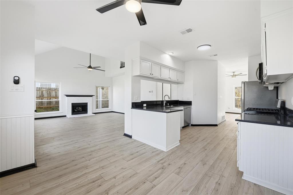 10120 Long Rifle Drive Fort Worth, TX 76108 - Photo 27 of 28 a kitchen with granite countertop a stove top oven a sink dishwasher and a refrigerator with wooden floor