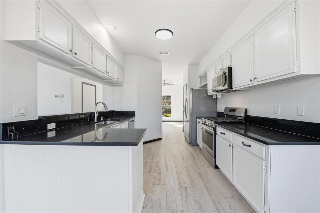 10120 Long Rifle Drive Fort Worth, TX 76108 - Photo 9 of 28 a kitchen with stainless steel appliances granite countertop a sink a stove and cabinets