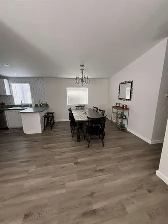a living room with furniture and a dining table with wooden floor